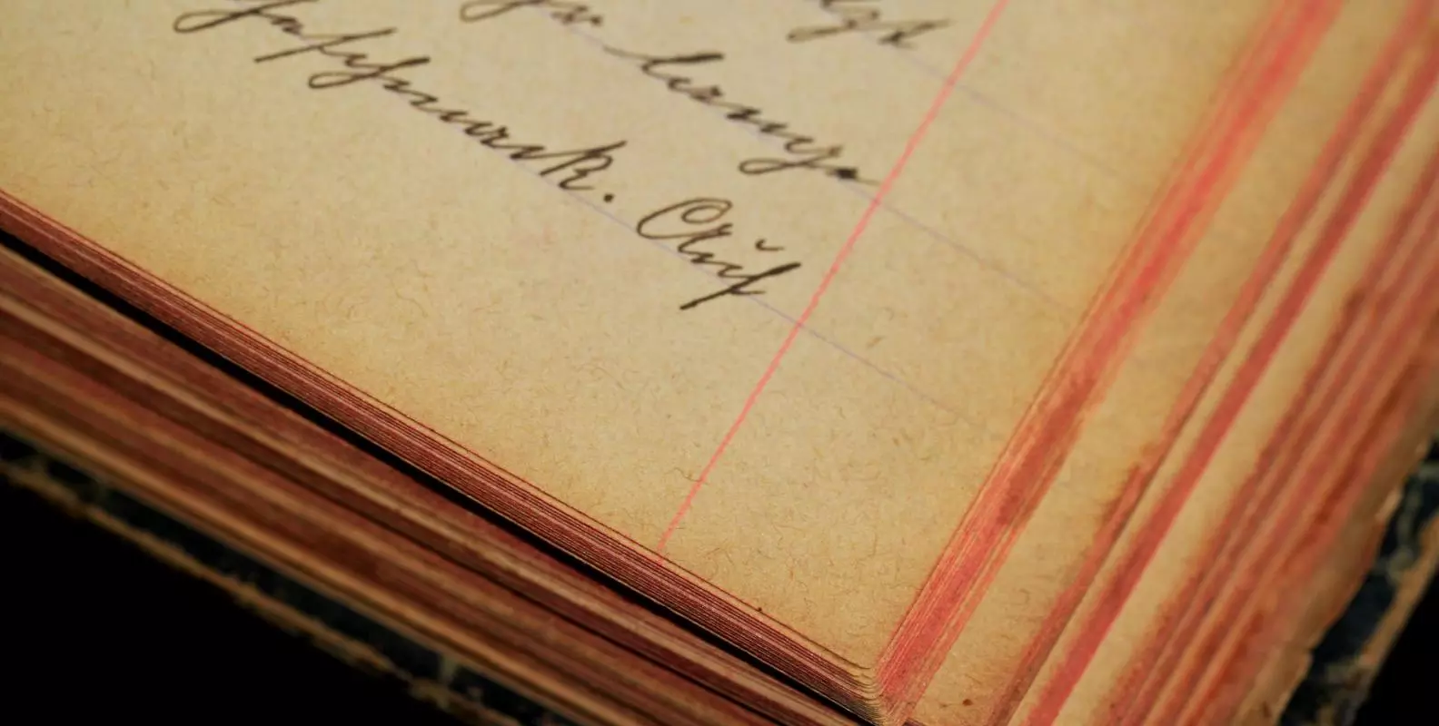 Corner of an old lined notebook with cursive handwriting in ink