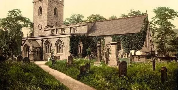 An old postcard of Eyam church and graveyad